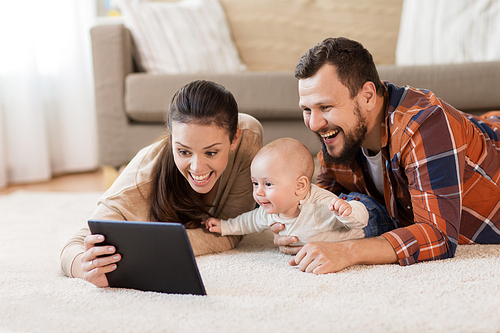 family, parenthood and people concept - happy mother and father showing tablet pc computer to baby at home