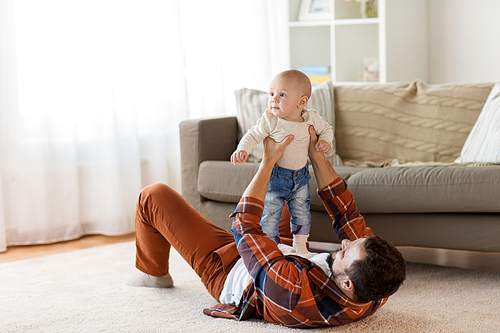 family, parenthood and people concept - happy father playing with little baby boy at home