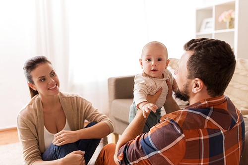 family, parenthood and people concept - happy mother, father and baby at home