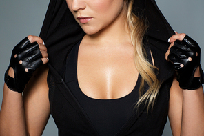 sport, fitness and people concept - close up of young woman in black sportswear posing in gym