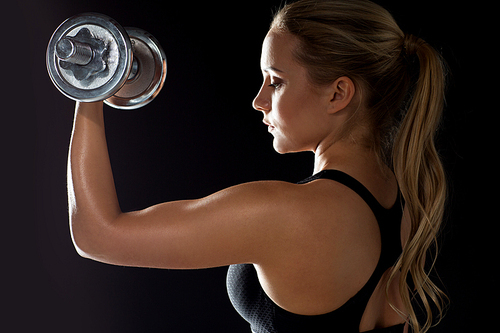 sport, fitness and people concept - young sporty woman exercising with dumbbell