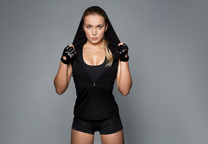 sport, fitness and people concept - young woman in black sportswear posing in gym