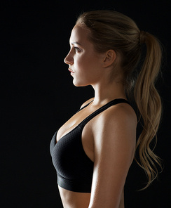 sport, fitness and people concept - young woman in black sportswear posing in gym
