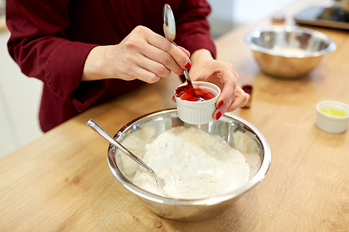 cooking, baking and people concept - chef hands with flour in bowl and food color additive making batter or dough