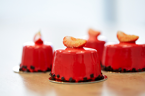 cooking, confectionery, baking  and food concept - strawberry mirror glaze cakes