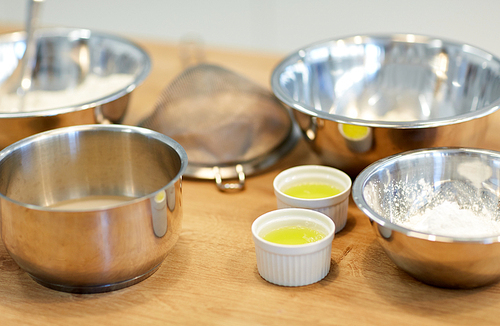 cooking food and baking concept - bowls with flour and egg whites at bakery kitchen