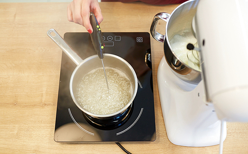 cooking, food and kitchen appliances concept - electric mixer and pot on stove