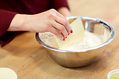 cooking food, baking and people concept - chef with spatula stirring flour in bowl and making batter or dough
