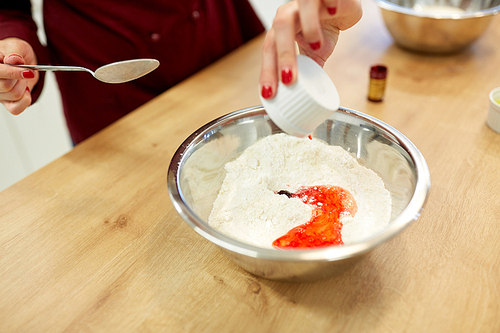 cooking, baking and people concept - chef hands with flour in bowl and food color additive making batter or dough