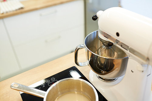 cooking, food and kitchen appliances concept - electric mixer and pot on stove