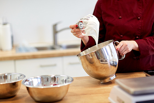 cooking, food and people concept - chef with whisk and whipped egg whites at kitchen