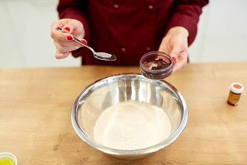 cooking, baking and people concept - chef hands with flour in bowl and food color additive making batter or dough