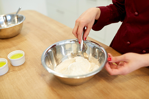 cooking food, baking and people concept - chef with flour in bowl making batter or dough