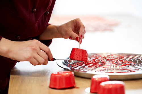 cooking, baking and confectionery concept - chef serving mirror glaze cakes at pastry shop