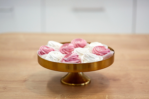 food, confection and sweets concept - zephyr, marshmallow or whipped cream on cake stand