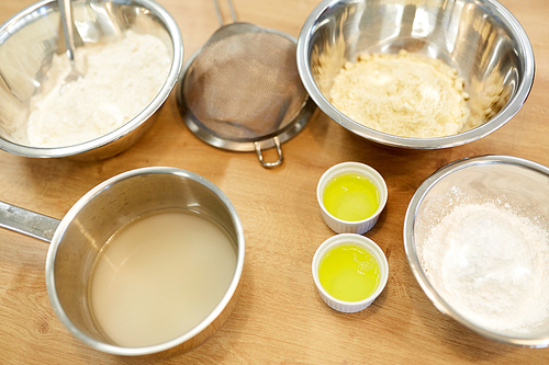 cooking food and baking concept - bowls with flour and egg whites at bakery kitchen
