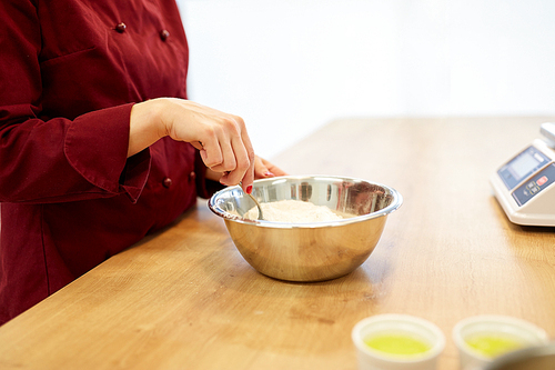 cooking food, baking and people concept - chef with flour in bowl making batter or dough