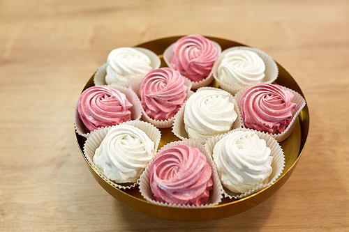 food, confection and sweets concept - zephyr, marshmallow or whipped cream on cake stand