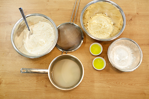 cooking food and baking concept - bowls with flour and egg whites at bakery kitchen