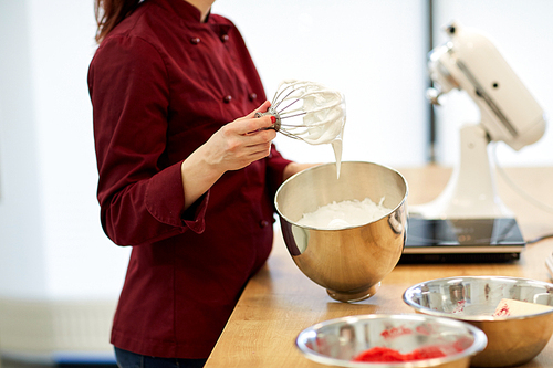 cooking, food and people concept - chef with whisk and whipped egg whites at kitchen