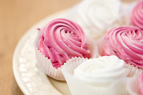 food, confection and sweets concept - close up of zephyr or marshmallow dessert on plate