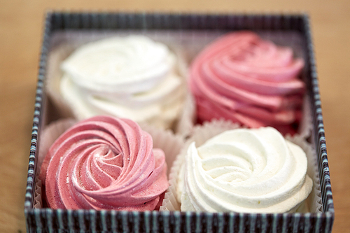 food, confection and sweets concept - zephyr, marshmallow or whipped cream in gift box