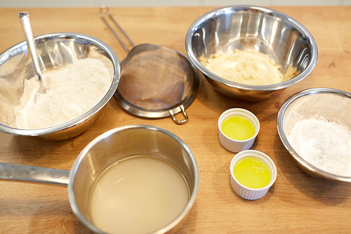 cooking food and baking concept - bowls with flour and egg whites at bakery kitchen