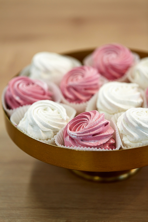 food, confection and sweets concept - close up of zephyr, marshmallow or whipped cream on cake stand