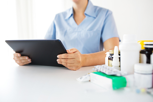 medicine, healthcare and technology concept - nurse or doctor with drugs and tablet pc computer at hospital