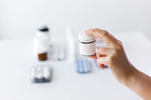 medicine, healthcare and people concept - close up of doctor hand with showing jar with drug