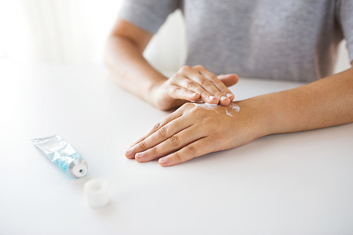 medicine, healthcare and people concept - close up of woman hands applying cream or therapeutic salve