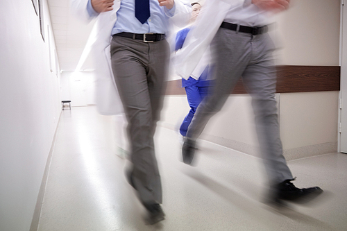 people, health care and medicine concept - group of medics running along hospital (motion blur effect)