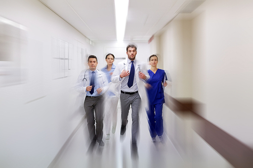 people, health care and medicine concept - group of medics running along hospital (motion blur effect)