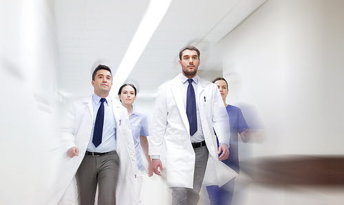 people, health care and medicine concept - group of medics walking along hospital (motion blur effect)
