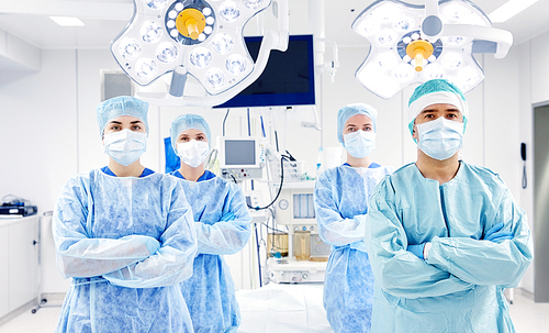 surgery, medicine and people concept - group of surgeons in operating room at hospital