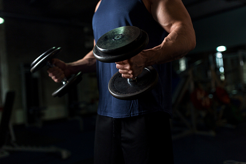 sport, bodybuilding, fitness and people concept - close up of young man with dumbbells flexing muscles in gym