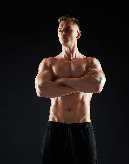 sport, bodybuilding, fitness and people concept - young man or bodybuilder with bare torso over black background