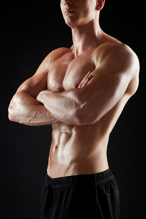 sport, bodybuilding, fitness and people concept - close up of young man or bodybuilder with bare torso over black background