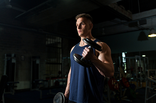 sport, bodybuilding, fitness and people concept - young man with dumbbells flexing muscles in gym