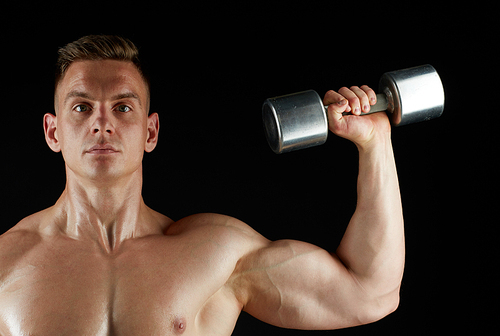 sport, bodybuilding, fitness and people concept - young man with dumbbells flexing muscles over black background