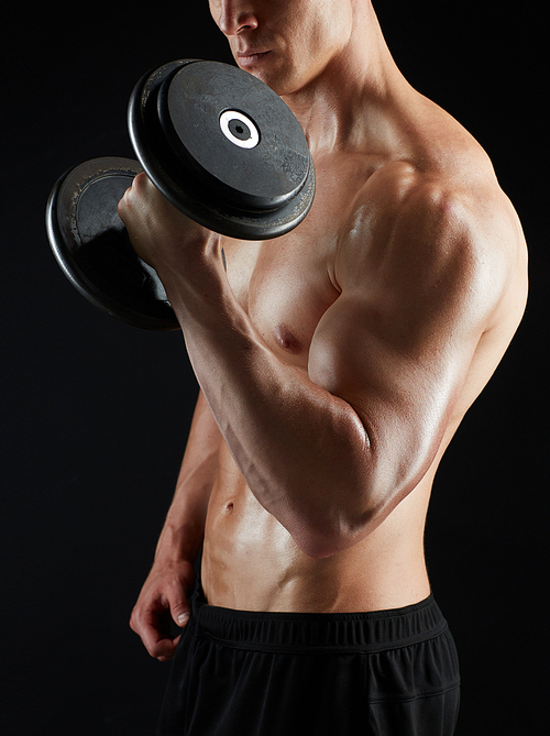 sport, bodybuilding, fitness and people concept - close up of young man with dumbbells flexing muscles over black background