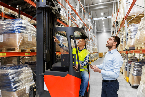 logistic business, technology and people concept - loader on forklift and businessman with tablet pc computer at warehouse