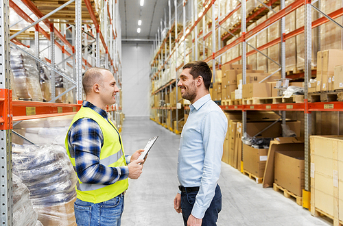 wholesale, logistic business and people concept - manual worker and businessman with clipboards at warehouse