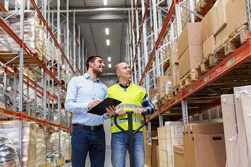 logistic business, shipment and people concept - businessman with clipboard and warehouse worker with loader