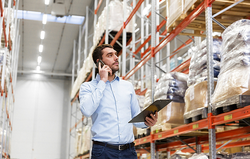 wholesale, logistic business, technology and people concept - businessman calling on smartphone at warehouse