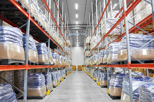 logistic, storage, shipment and industry concept - cargo storing at warehouse shelves