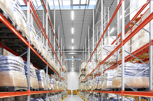 logistic, storage, shipment and industry concept - cargo storing at warehouse shelves