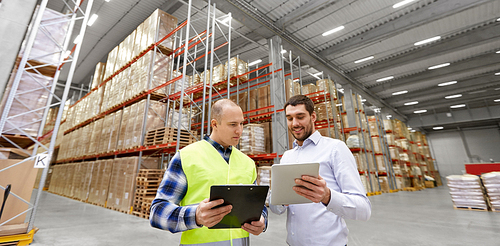 logistic business, shipment and people concept - warehouse worker and businessman with clipboard and tablet pc computer