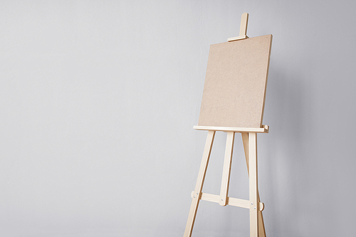 fine art, creativity and artistic tools concept - wooden easel at studio