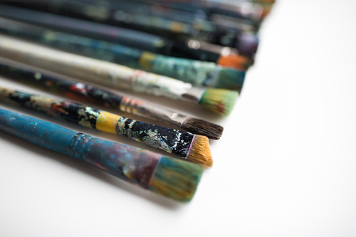 fine art, painting, creativity and artistic tools concept - dirty paintbrushes